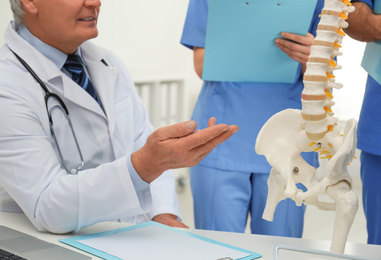 Photo of Professional orthopedist teaching medical students in clinic, closeup