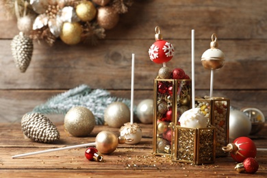 Composition with delicious Christmas ball cake pops on wooden table. Space for text