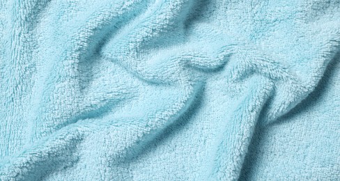 Photo of Texture of soft light blue crumpled fabric as background, top view
