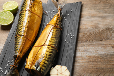 Photo of Tasty smoked fish on wooden table. Delicious seafood