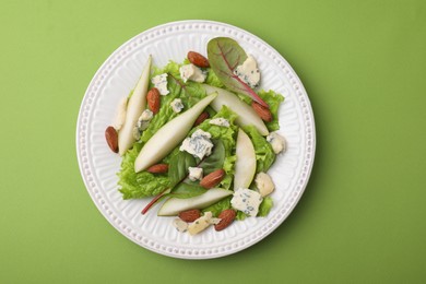 Photo of Delicious pear salad on green background, top view