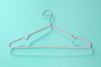Photo of Two hangers on light blue background, top view