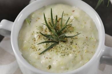 Photo of Delicious cream soup with tarragon, spices and potato in bowl, closeup