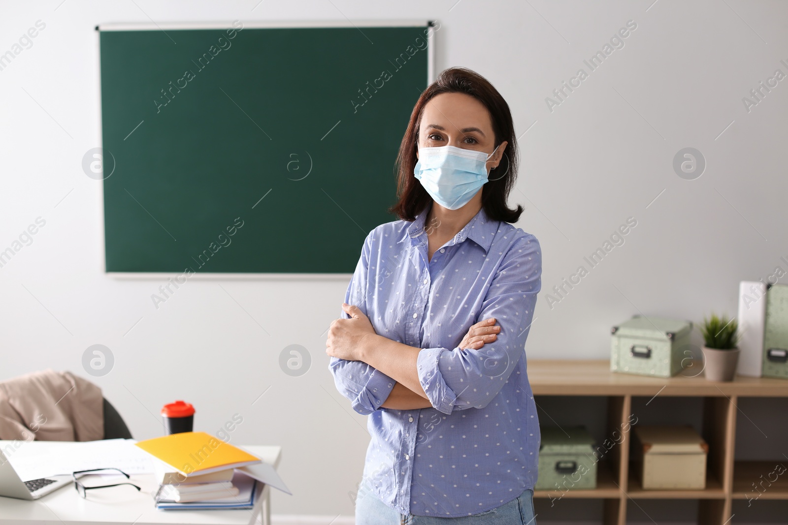 Photo of Teacher with protective mask in classroom. Reopening after Covid-19 quarantine