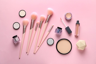 Flat lay composition with makeup brushes on pink background