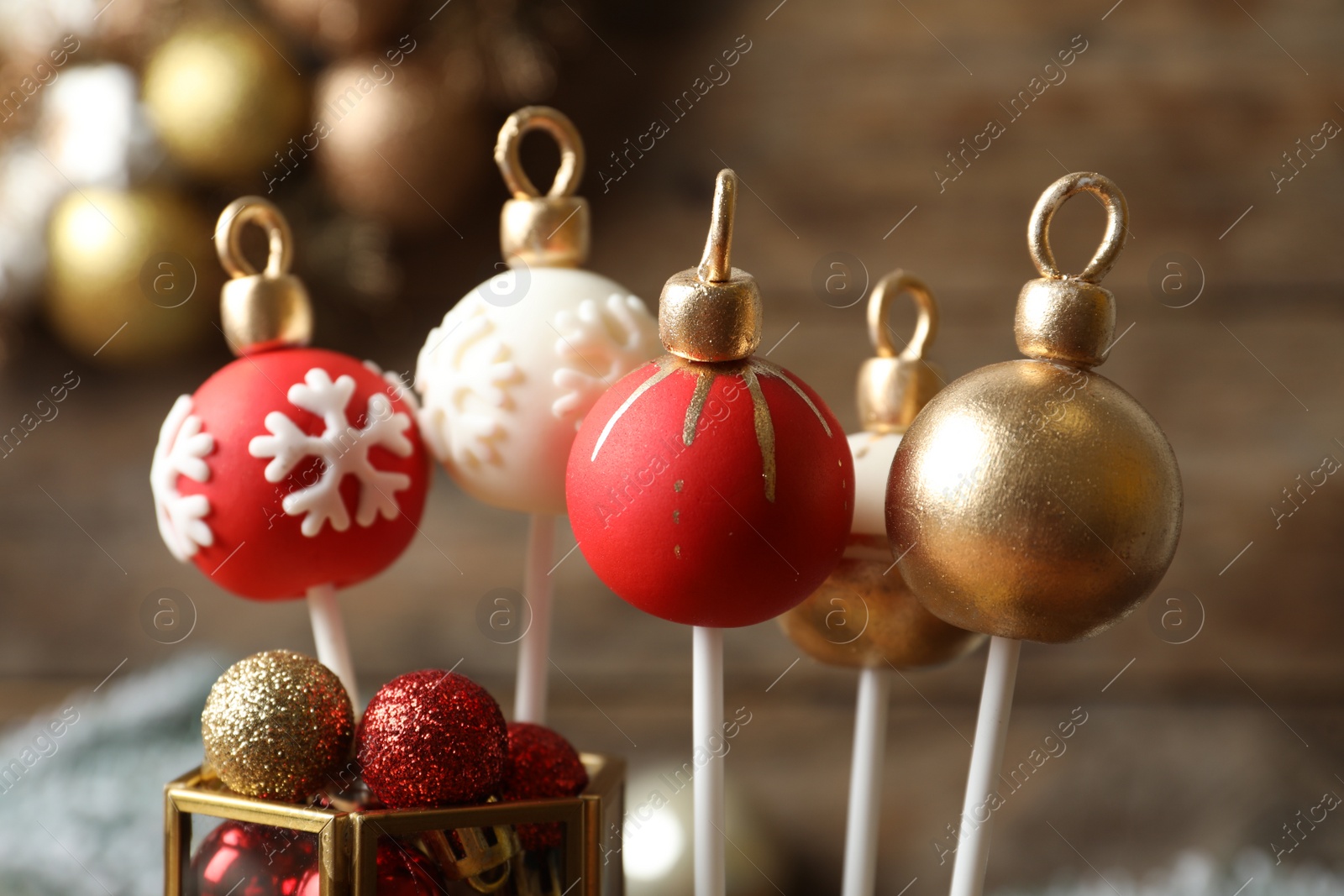 Photo of Delicious Christmas ball cake pops on blurred background, closeup