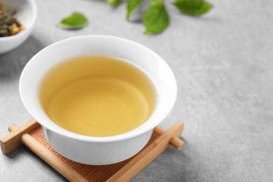 Photo of Cup of green tea on grey table