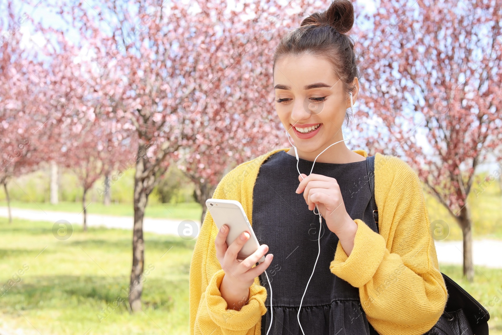 Photo of Young woman talking by phone outdoors on sunny day