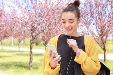 Photo of Young woman talking by phone outdoors on sunny day