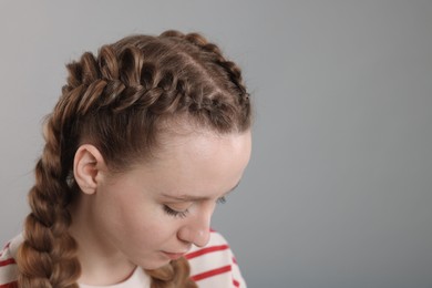 Photo of Woman with braided hair on grey background, space for text