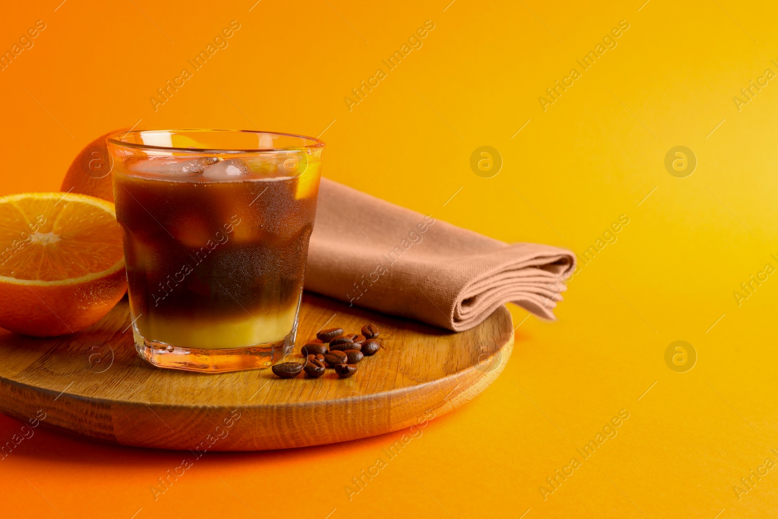 Photo of Tasty refreshing drink with coffee and orange juice on bright color background, space for text