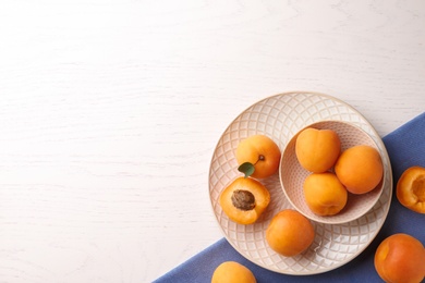 Composition with delicious apricots on white wooden background, top view. Space for text