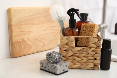 Different cleaning supplies in basket on countertop. Space for text