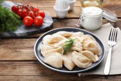 Plate of tasty dumplings served on wooden table