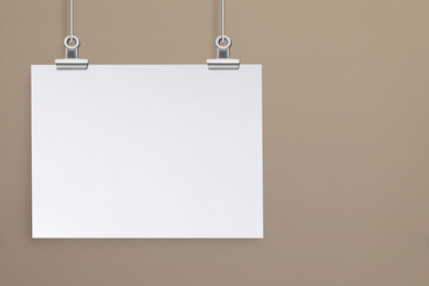 Image of Blank poster hanging near beige wall. Space for design