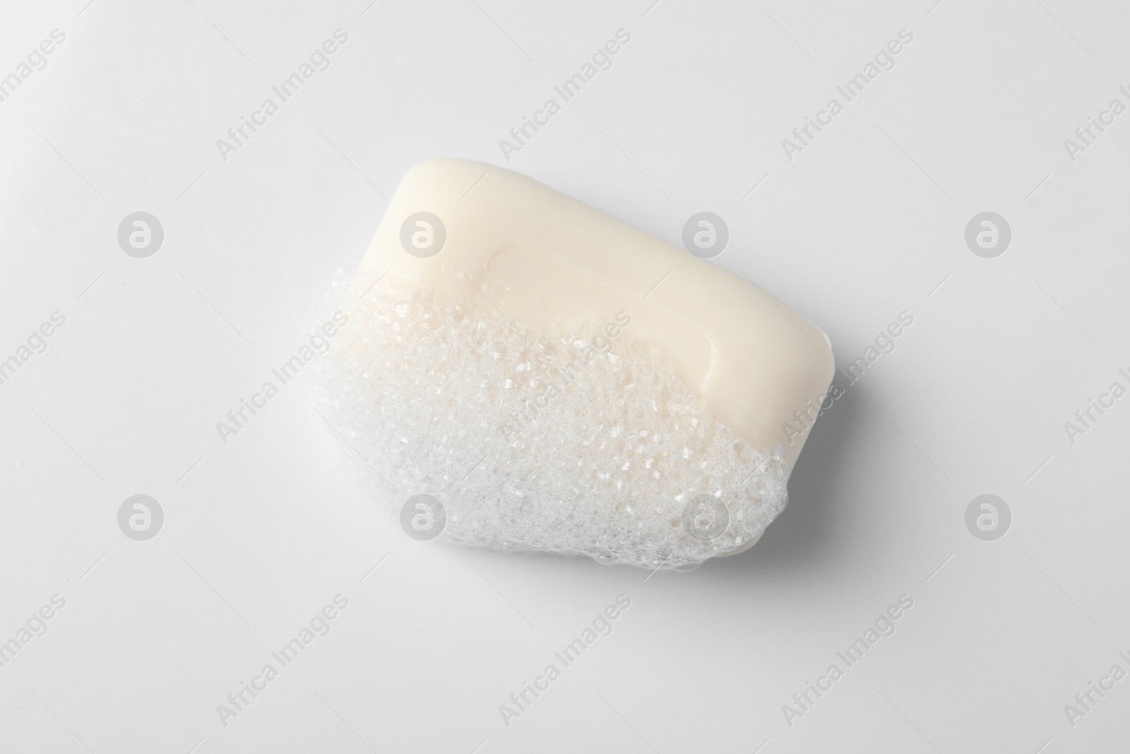 Photo of Soap with fluffy foam on white background, top view