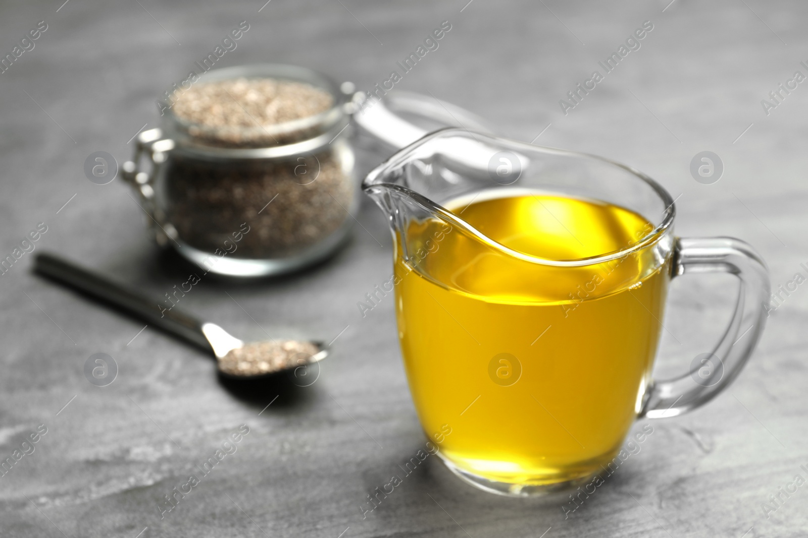 Photo of Composition with chia oil and seeds on grey background