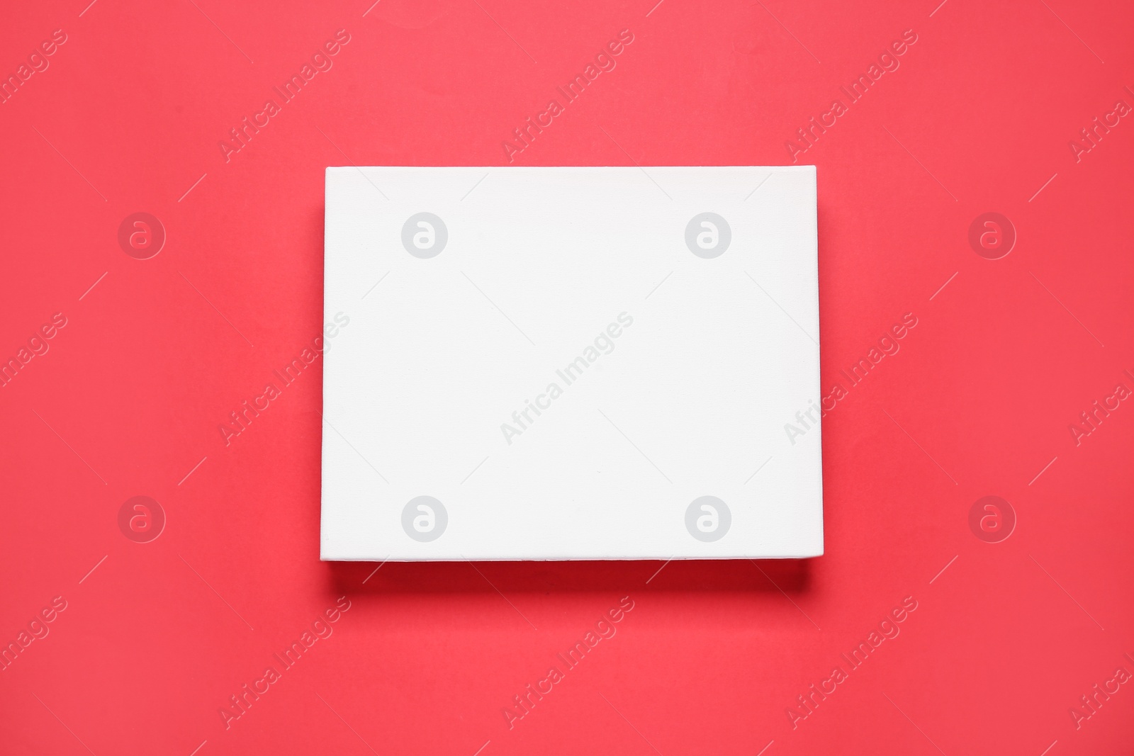 Photo of Blank canvas on red background, top view. Space for design