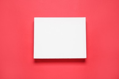 Photo of Blank canvas on red background, top view. Space for design