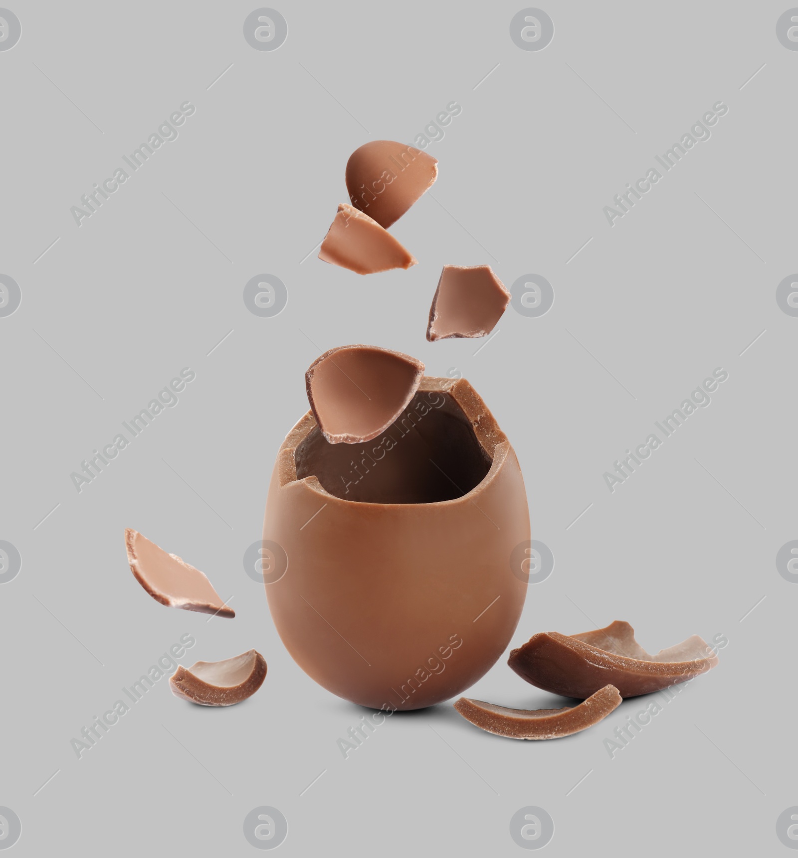 Image of Exploded milk chocolate egg on grey background