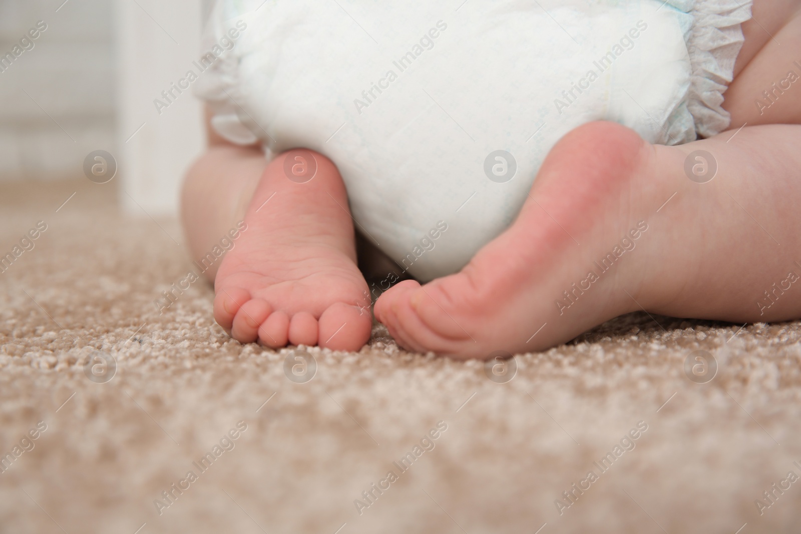 Photo of Cute little baby crawling on carpet indoors, closeup