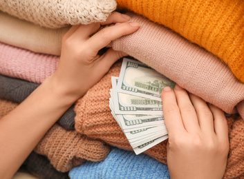 Photo of Woman hiding money between clothes, closeup. Financial savings