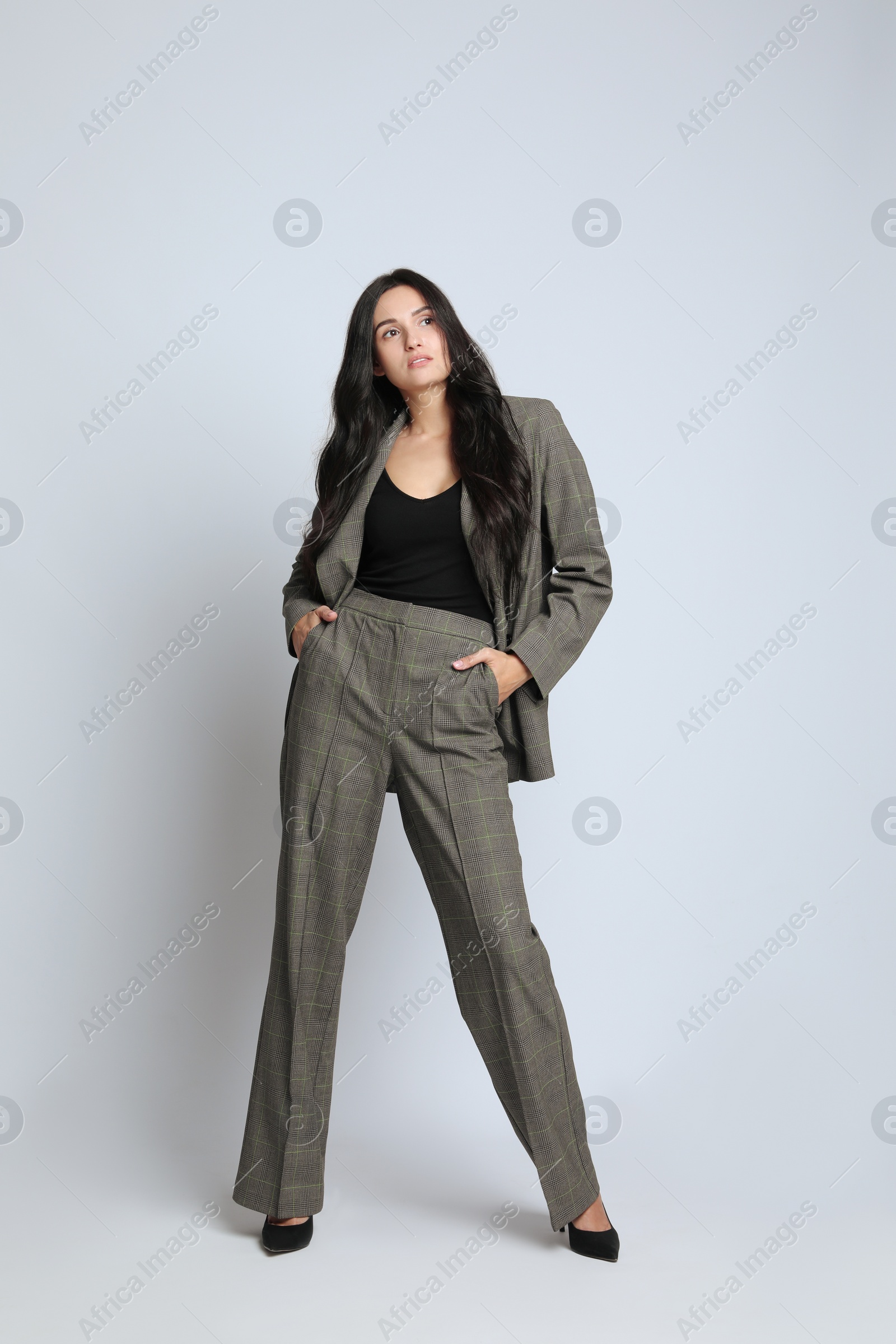 Photo of Full length portrait of beautiful woman in formal suit on light background. Business attire