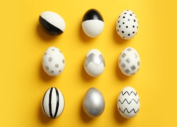 Photo of Flat lay composition with painted Easter eggs on color background