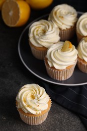 Photo of Delicious cupcakes with white cream and lemon zest on table