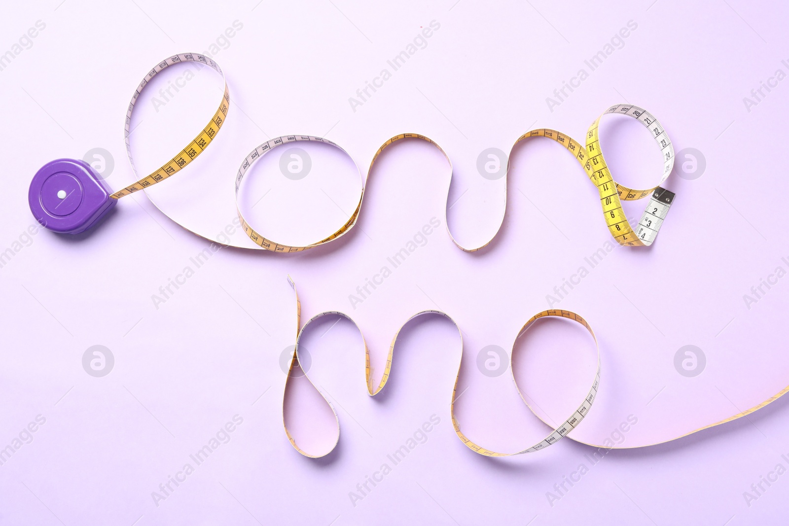 Photo of Phrase Love Me of measuring tape on pink background, top view