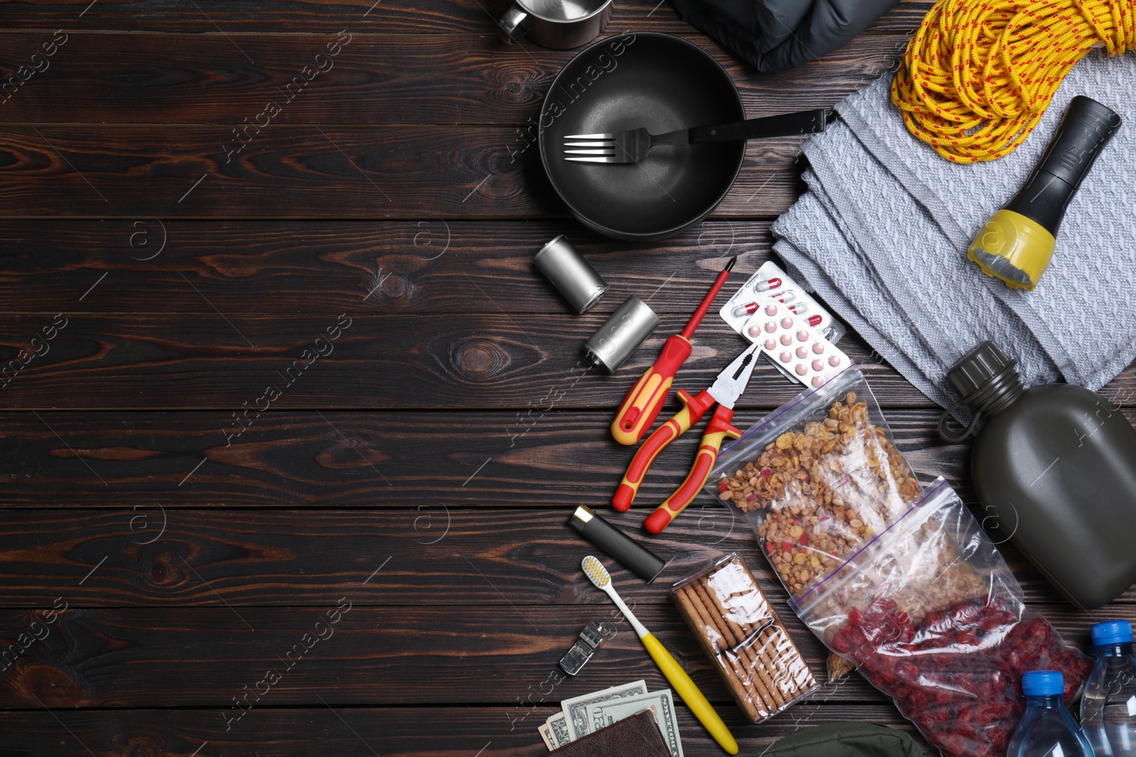 Photo of Earthquake supply kit on wooden table, flat lay. Space for text