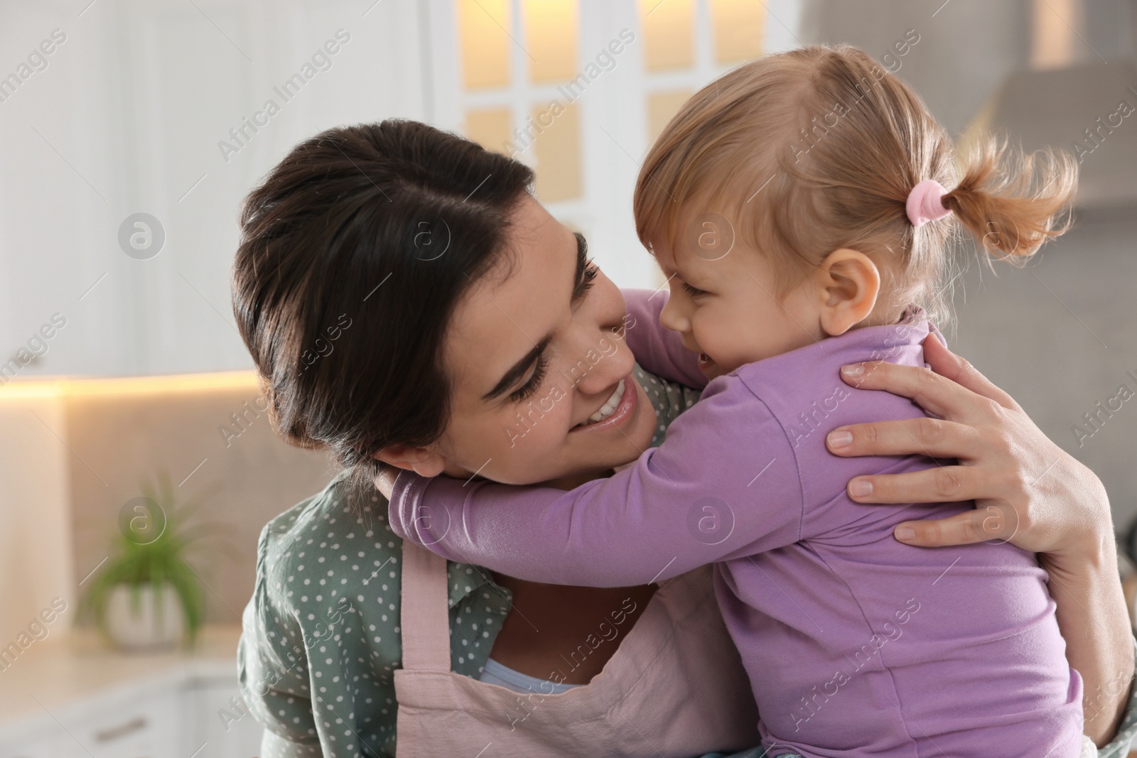 Photo of Mother and her little daughter spending time together in kitchen