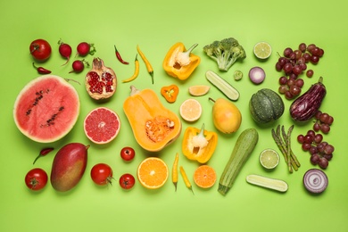 Photo of Fresh organic fruits and vegetables on green background, flat lay