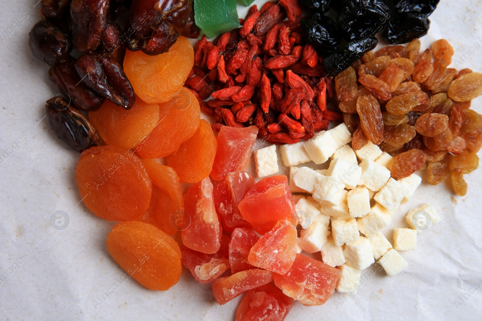 Photo of Pile of different dried fruits on white background, closeup