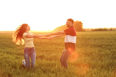 Happy young couple in green field on sunny spring day