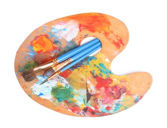 Photo of Palette with paints and brushes on white background, top view. Artist equipment