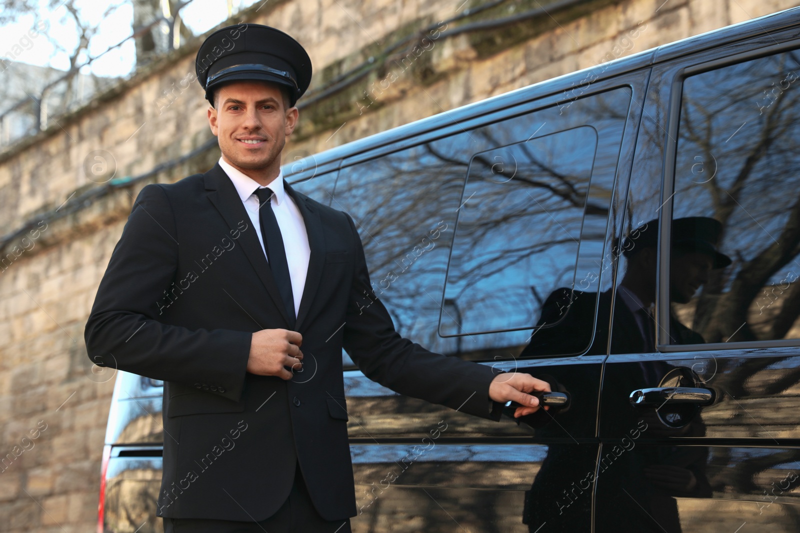 Photo of Professional driver near luxury car outdoors. Chauffeur service