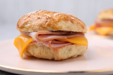 Photo of Delicious bagel with ham and cheese on plate, closeup