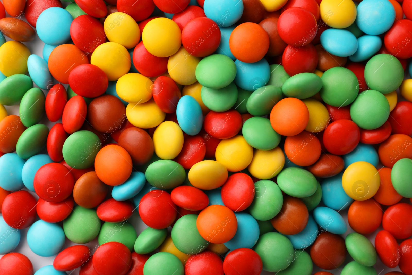 Photo of Many small colorful candies as background, top view