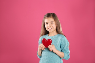 Portrait of girl with decorative heart on color background