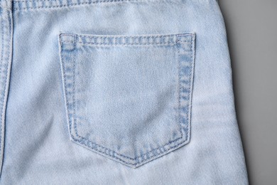 Jeans with pocket on light grey background, top view