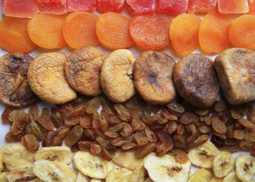 Different tasty dried fruits as background, top view