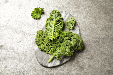 Photo of Fresh kale leaves on grey table, flat lay