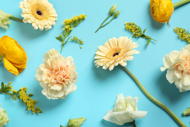 Floral composition with beautiful flowers on light blue background, flat lay