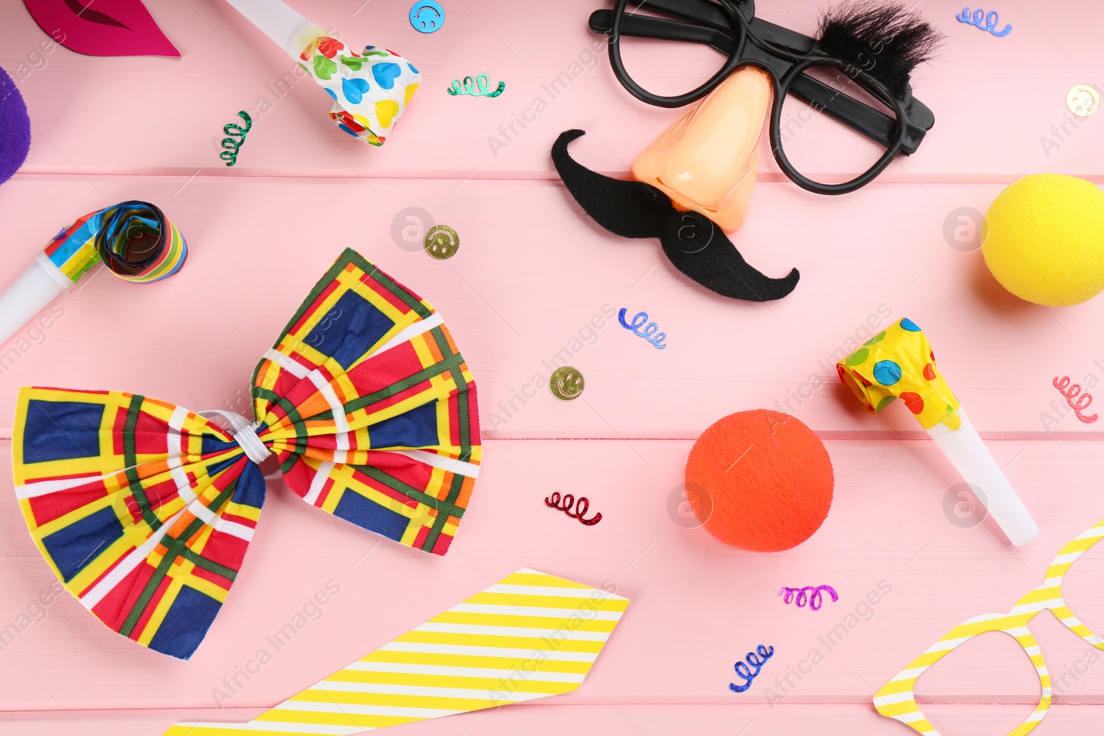 Photo of Flat lay composition with clown's items on pink wooden table