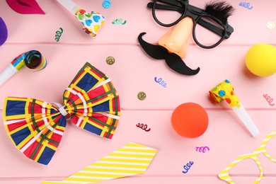 Flat lay composition with clown's items on pink wooden table