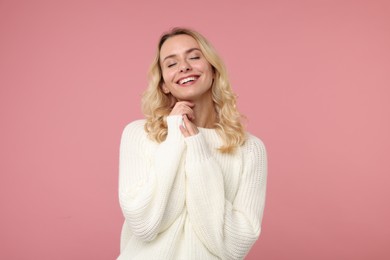 Photo of Happy woman in stylish warm sweater on pink background