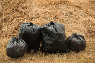 Photo of Trash bags full of garbage outdoors. Space for text