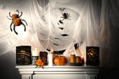 Photo of Different Halloween decor on fireplace indoors. Festive interior