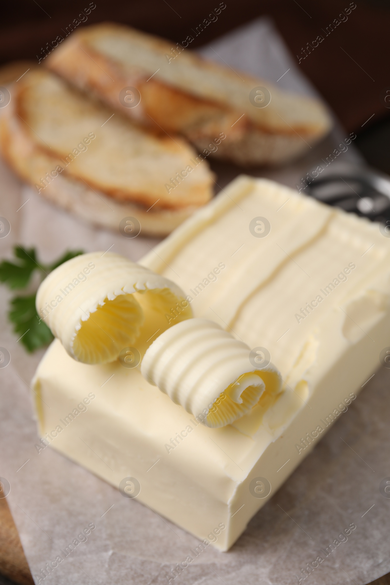 Photo of Tasty butter and slices of bread on table, closeup